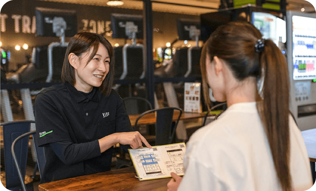 女性が入会資料の説明をしている