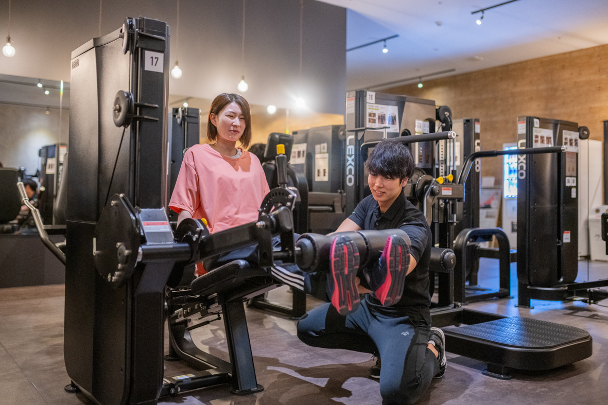 スタッフがマンツーマンでマシンの使い方を説明している様子
