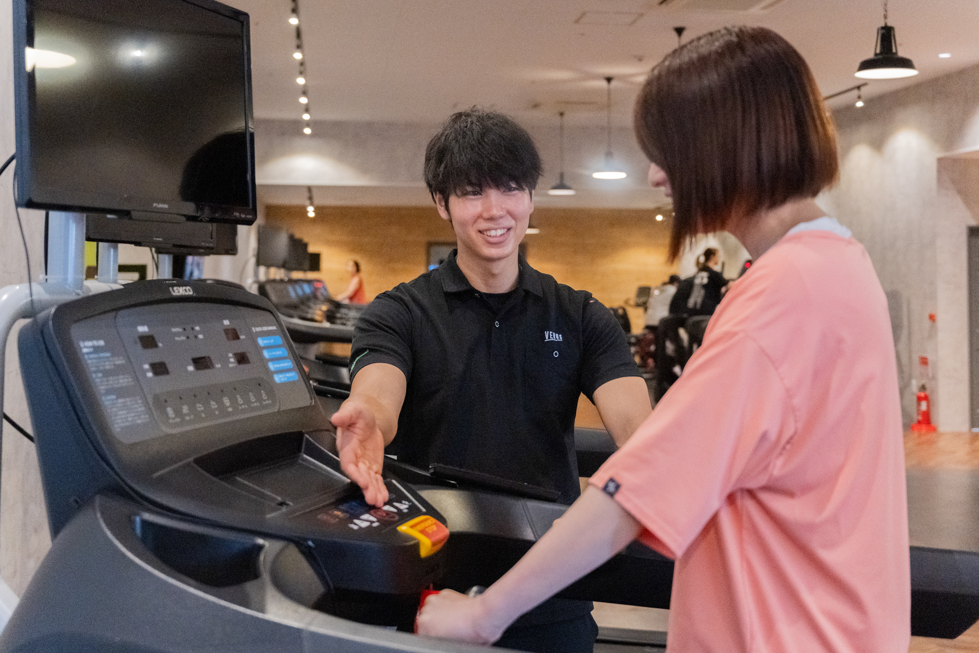スタッフがマシンの使い方をていねいに説明している様子